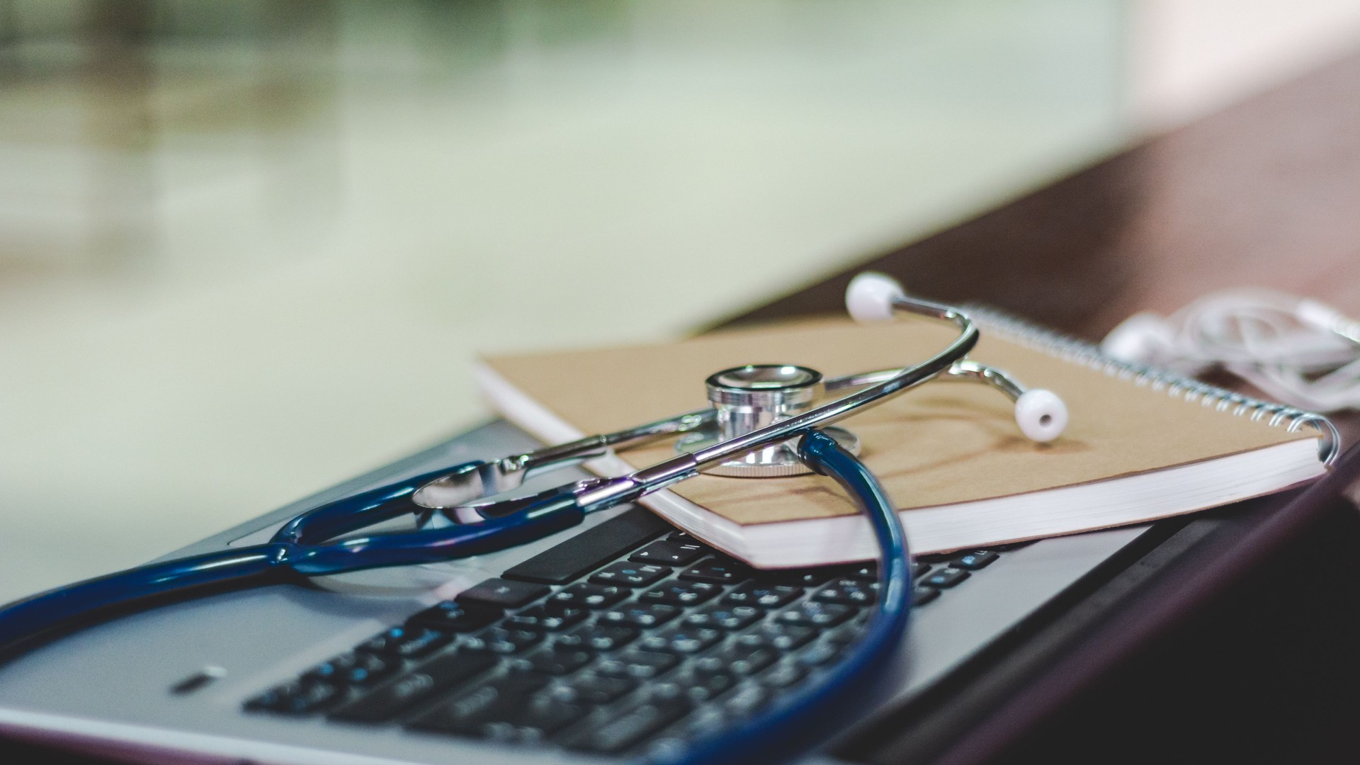 Close-Up Of Stethoscope With Book On Laptop At Table